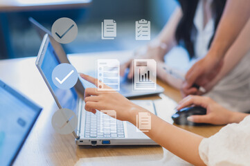 会議でパソコンを操作しながら意見交換する女性たち