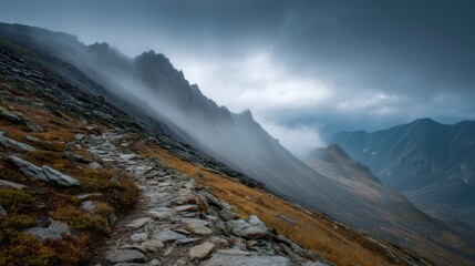 The mountain range is covered in fog and the sky is cloudy. The misty atmosphere gives the scene a mysterious and serene mood