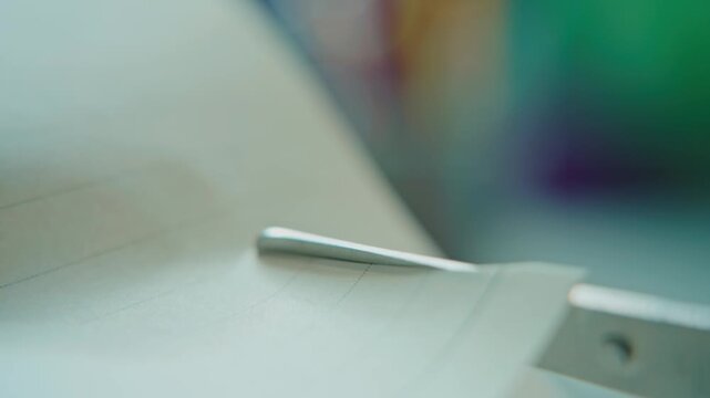 Close-up of scissors cutting paper in a creative and focused activity