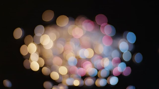Beautifully diffused soft residual light bokeh gradually expanding and gently contracting in slow motion against a solid, deep, uniform black background mystery, template, gentle
