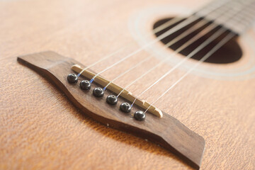 headstock. A detailed close-up of an acoustic guitar, focusing on its wooden texture and artistic craftsmanship. tutorial guides, club newsletters, designed for sports & leisure club marketing.