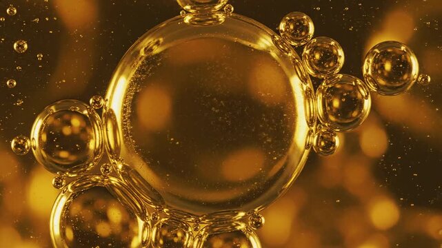 Abstract macro slow motion close-up of large spherical bubbles of gold oil fluid continually flowing and merging together in constant hypnotic repetition dynamic, gold oil fluid, surface