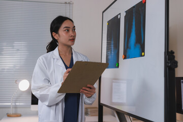 Young doctor analyzing medical x rays on whiteboard
