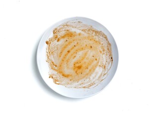 Dirty white plate with leftovers food isolated on white background. Top view 
