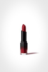 Luxurious red lipstick with black casing on a white background