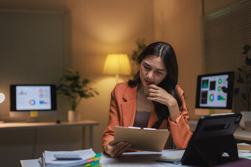 Young woman analyzing data working late at night