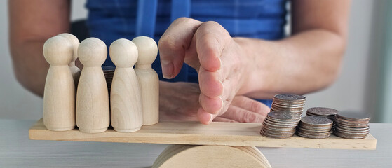 Balancing the scales of value with wooden figures and coins in a financial discussion concept