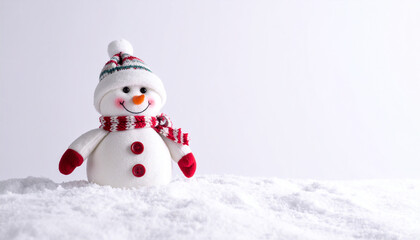 Obraz premium Cute Snowman Toy with Red Hat and Scarf on Real Snow Over a White Background
