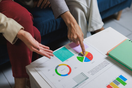 People analyzing marketing data using pie charts on table