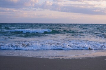 Ocean waves breaking along the shoreline at dusk