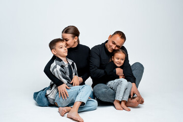 Fototapeta premium family with two children, mom, dad, son, and daughter on a white isolated background, hugging, a young happy family
