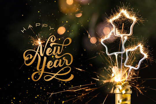 Happy new year wishes written in gold script with fireworks for the celebration holiday