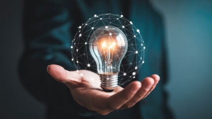 Illuminated light bulb encased in a glowing digital network held in an open palm