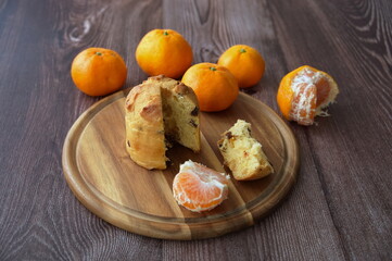 High angle view of Christmas bread with tangerines on wooden plate