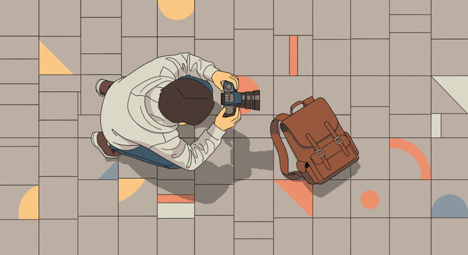 An overhead view captures a casual photographer on a geometrically patterned tiled ground, holding a camera next to a stylish brown backpack, illustrating urban creativity.