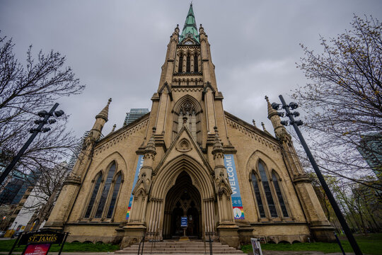 Historic Gothic cathedral facade in downtown Toronto with tall spire and arched entrance - Powered by Adobe