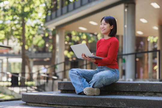Young woman learning coding using laptop outdoors