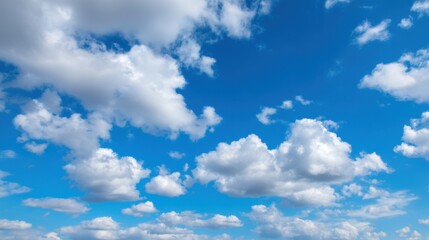 Naklejka premium The sky is blue with many clouds. The clouds are scattered throughout the sky, and the sun is shining brightly. Scene is peaceful and serene, as the blue sky and clouds create a calming atmosphere