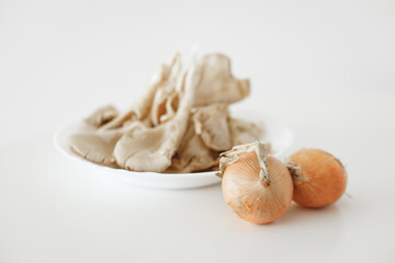 Oyster mushrooms and onions ready for cooking on white background