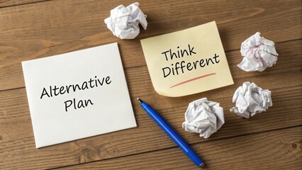 Creative workspace with notes promoting alternative plans and innovative thinking on wooden background with crumpled paper