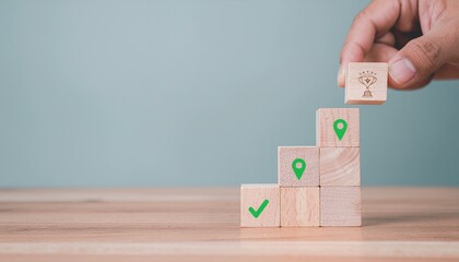 Hand stacking wooden blocks with icons symbolizing progress towards a trophy