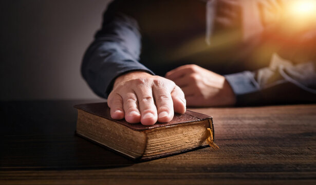 Oath. Hand on the Holy Bible. Taking the oath of allegiance. Sitting at the table a man in a shirt and jacket