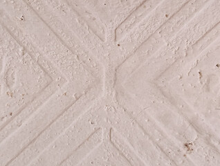 Close-up abstract background of pale cream textured concrete wall with diagonal cross pattern design element