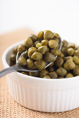 Pickled capers on white background. Healthy food ingredient