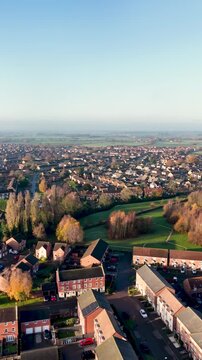 Portrait vertical aerial drone footage of the town of Batley in Wakefield in the UK, showing a typical British housing estate with rows of houses and homes in the West Yorkshire town in the winter