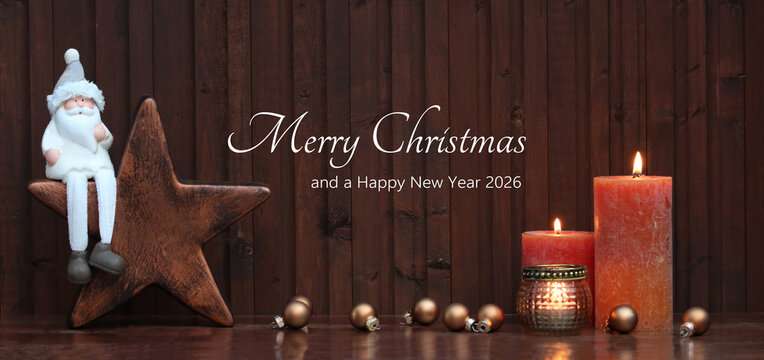 Burning candles with Christmas baubles and Santa Claus in front of a wooden background. The greeting "Merry Christmas and a Happy New Year" is written on the wood. - Powered by Adobe