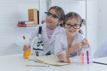 Group of sibling students kids lab coat uniform studying science class in laboratory, Iranian pupils girls scientists having fun at school in lab with microscope and test tube, kid scientist concept