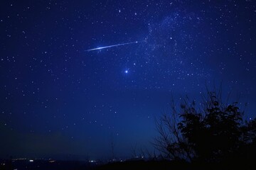 Fototapeta premium Stunning night sky view featuring a bright meteor streaking across the milky way, with city lights visible on the horizon
