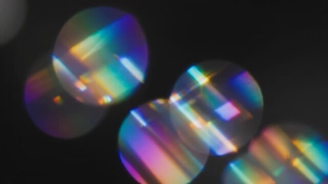 Extremely slow motion cinematic shot of iridescent spectral light refractions causing soft bokeh flares to shimmer and dance against a deep black void optical, cinematic, shimmering