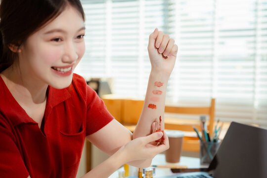 Asia vlogger woman influencer, SME retail store owner smile enjoy selling show live sale online screen smartphone and laptop work at home.