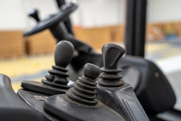 Forklift control joysticks and steering wheel in warehouse interior