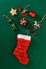 Christmas stocking with traditional ornaments like rocking horse and wooden sleigh on green...