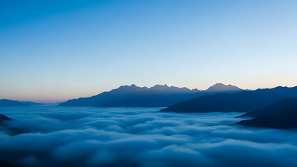Mountains silhouetted against a blue sky above a sea of clouds