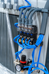 Industrial pneumatic control unit with blue hoses and pressure regulator