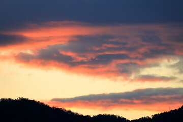 夕日に染まった山向こうの雲