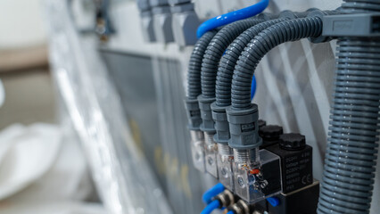 Industrial electrical installation with flexible conduits and connectors on control panel