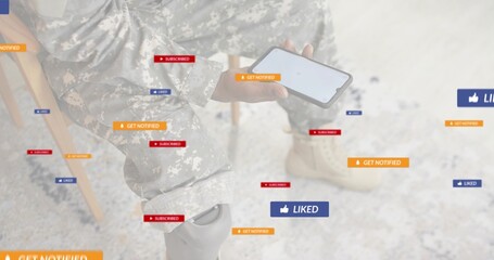 Sitting soldier wearing camouflage uniform holding smartphone in pale room, showing floating alerts
