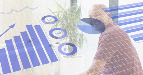 Smiling man wearing polo sitting at office, showing bar chart, rings 102 or 190 or 334, copy space