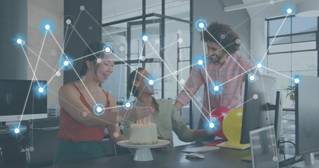 Celebrating 3 coworkers in office attire reaching toward cake at open office with digital overlay © vectorfusionart