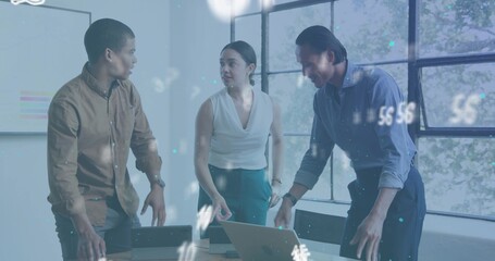 Discussing team of 3 leaning over table reviewing open laptop in office in business casual