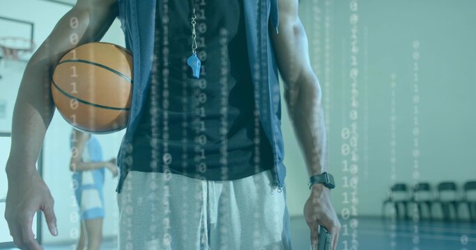 Holding coach's basketball and phone while standing on gym court, hoodie and binary overlay