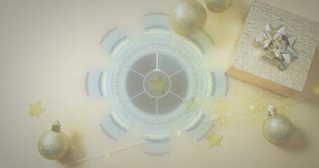 Displaying central circular graphic glowing on pale beige table with silver gift and gold baubles