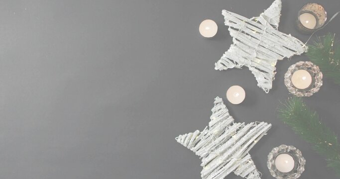 Naklejki Showing display at right on gray tabletop with white woven stars, lit votives, garland, copy space