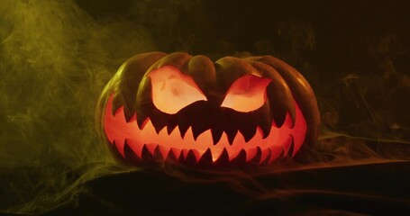 Glowing carved jack-o'-lantern showing jagged mouth and arched eyes on tabletop, with greenish fog