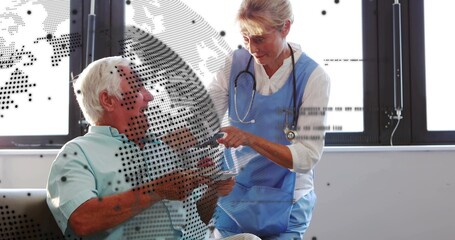 Senior nurse in blue tunic with stethoscope handing pill box to patient at clinic, dotted overlay