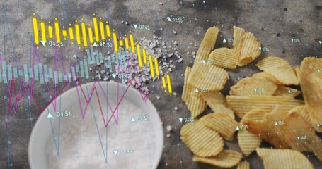 Displaying ridged chips clustered on right of tabletop with salt bowl, market charts, copy space